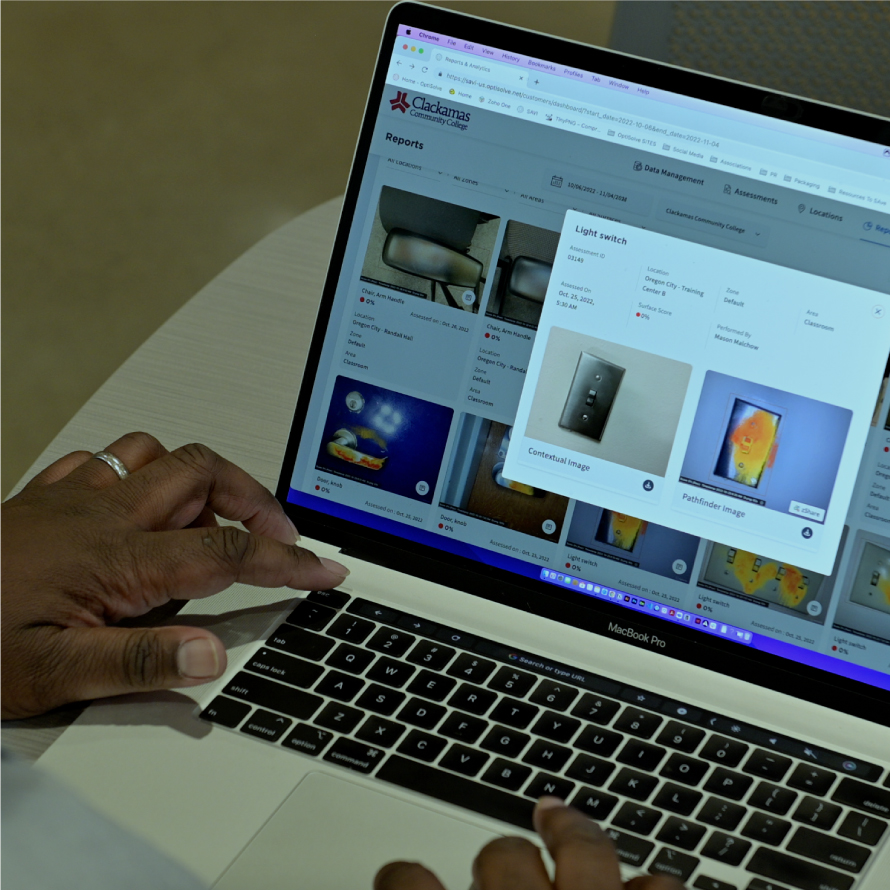 A male typing on a MacBook Pro laptop is reviewing Reports dashboard from the Optisolve Savi software.