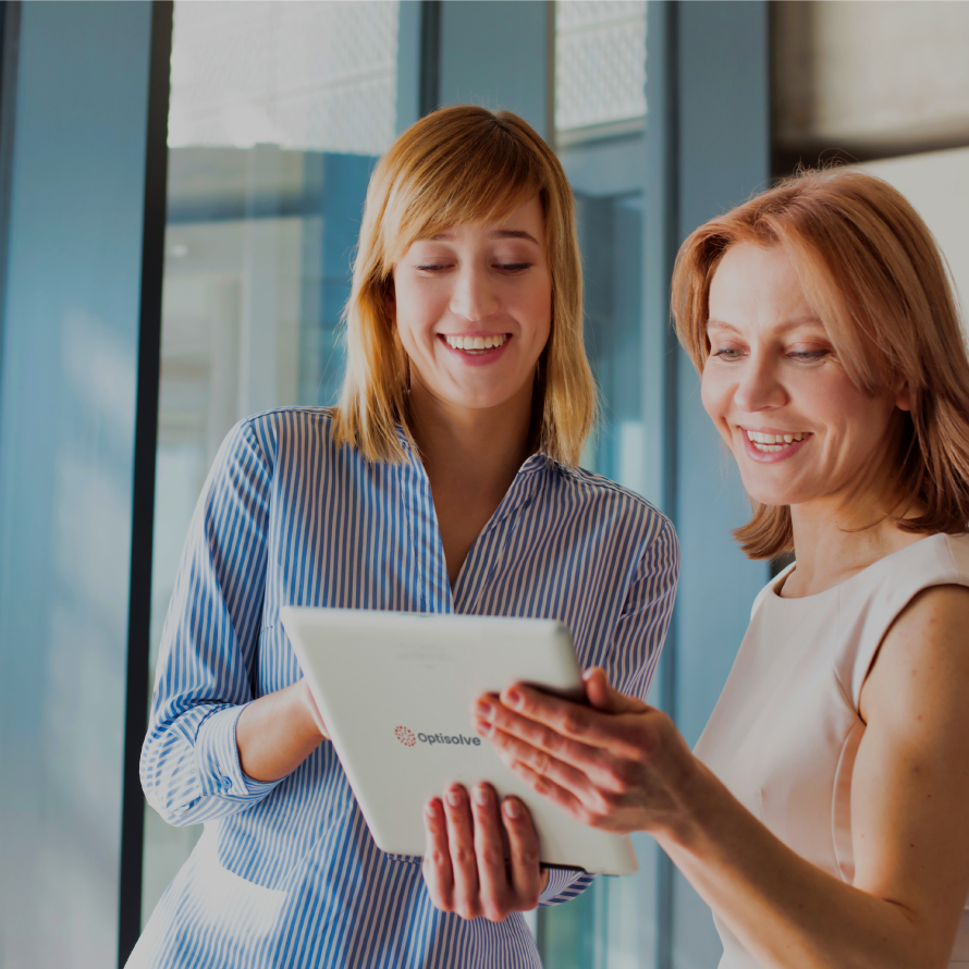 Two women looking at a white Optisolve branded iPad.